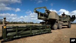 En esta imagen proporcionada por el ejército de EEUU, un soldado prepara la grúa para cargar el sistema de misiles tácticos del Ejército en el sistema de cohetes de artillería de alta movilidad (HIMARS) el 26 de julio de 2023. 