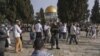 Policías israelíes escoltan a visitantes judíos en que celebran la Pascua judía en el complejo de la Mezquita de Al Aqsa, conocido por los musulmanes como Noble Santuario y por los judíos como Monte del Templo, en el casco antiguo de Jerusalén, el 9 de abril de 2023.