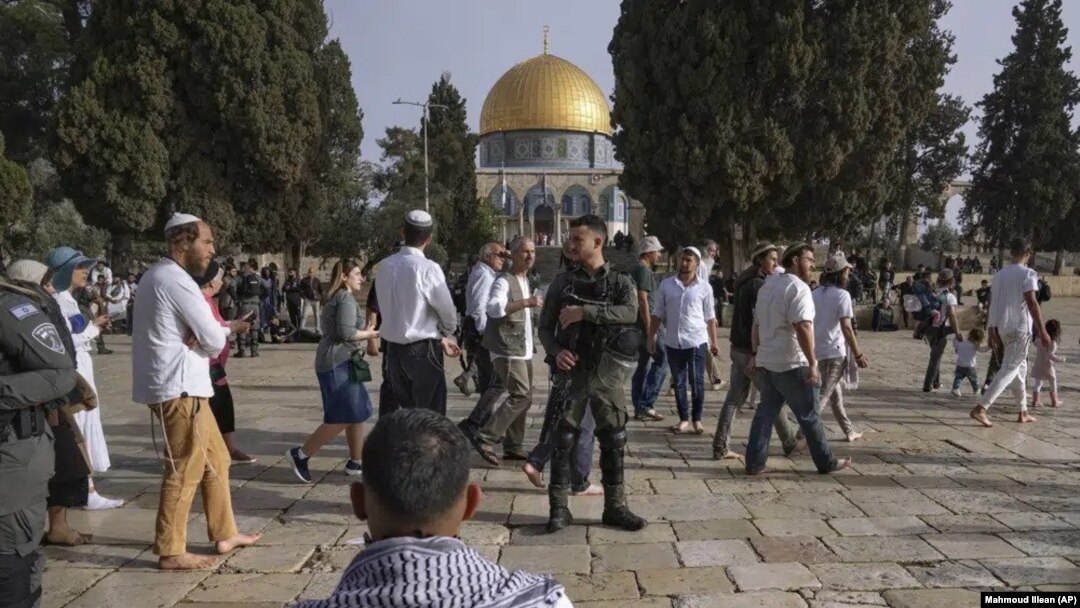 Policías israelíes escoltan a visitantes judíos en que celebran la Pascua judía en el complejo de la Mezquita de Al Aqsa, conocido por los musulmanes como Noble Santuario y por los judíos como Monte del Templo, en el casco antiguo de Jerusalén, el 9 de abril de 2023.