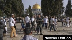 Policías israelíes escoltan a visitantes judíos en que celebran la Pascua judía en el complejo de la Mezquita de Al Aqsa, conocido por los musulmanes como Noble Santuario y por los judíos como Monte del Templo, en el casco antiguo de Jerusalén, el 9 de abril de 2023.