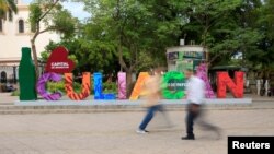 La gente camina junto un letrero que reza: Culiacán, en la ciudad del mismo nombre, en el estado de Sinaloa, México, el 8 de julio de 2023.