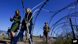 FILE - Concertina wire is seen as Republican members of Congress tour the Texas-Mexico border, Jan. 3, 2024, in Eagle Pass, Texas. 