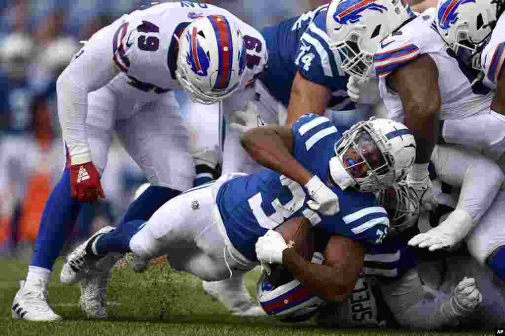 Indianapolis Colts running back Kenyan Drake, bottom, dives forward against the Buffalo Bills during the second half of an NFL preseason football game in Orchard Park, N.Y., Aug. 12, 2023. 