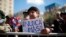 A person holds the Spanish phrase "Never again!" outside La Moneda presidential palace during a ceremony marking the 50th anniversary of the 1973 coup that toppled the government of late President Salvador Allende, in Santiago, Chile, Sept. 11, 2023.