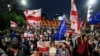 Demonstrators with Georgian national and EU flags rally during an opposition protest against a foreign influence bill as they mark their country's Independence Day, in the center of in Tbilisi, Georgia, May 26, 2024. 
