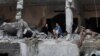 Palestinians sit among the rubble of a damaged residential building, in the aftermath of Israeli strikes, in Gaza City, Oct. 10, 2023. 