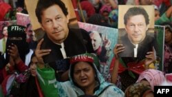 Supporters of Pakistan's former prime minister Imran Khan carry placards displaying a portrait of Khan during a protest in Karachi, March 19, 2023, demanding the release of party workers arrested in recent police clashes.
