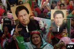 Supporters of Pakistan's former prime minister Imran Khan carry placards displaying a portrait of Khan during a protest in Karachi, March 19, 2023, demanding the release of party workers arrested in recent police clashes.