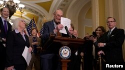 U.S. Senate Majority Leader Chuck Schumer holds up his notes at the beginning of a press conference announcing that he will unveil a new package of legislation to address competition with China on Capitol Hill in Washington, May 3, 2023. 