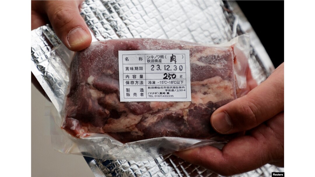 Daishi Sato, pemilik restoran Mie Soba dan mesin penjual otomatis, menunjukkan sebungkus daging Beruang Hitam Asia di sebelah mesin penjual otomatis di depan restorannya di Semboku, prefektur Akita , Jepang 6 April 2023. (REUTERS/Irene Wang)
