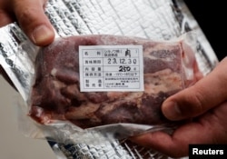 Daishi Sato, pemilik restoran Mie Soba dan mesin penjual otomatis, menunjukkan sebungkus daging Beruang Hitam Asia di sebelah mesin penjual otomatis di depan restorannya di Semboku, prefektur Akita , Jepang 6 April 2023. (REUTERS/Irene Wang)