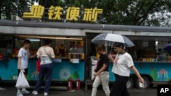 People visit a roadside food stall in Beijing, July 25, 2024.