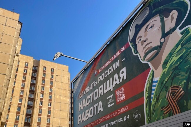 A billboard promoting contract army service and reading "Serving Russia is the real job" sits in Saint Petersburg on April 23, 2023.