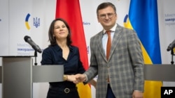 German Foreign Minister Annalena Baerbock, left, and Ukrainian Foreign Minister Dmytro Kuleba pose for a photo after a joint news conference following their talks in Kyiv, Ukraine, Sept. 11, 2022. 