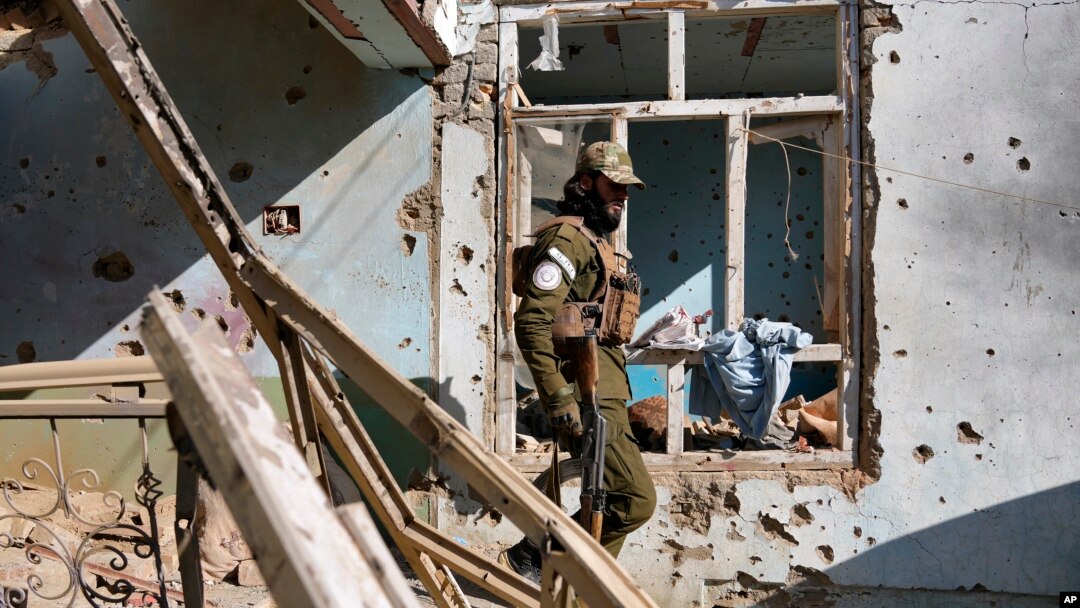 FILE - A Taliban fighter checks an Islamic State group house that was destroyed in the ongoing conflict between the two in Kabul, Afghanistan, Jan. 5, 2023. Taliban raided an Islamic State hideout in the capital, Feb. 14, 2023.
