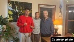 Li Xiaosan, center, and his son, left, visited with a local pastor after they came to the United States by way of the Mexican border. Their 50-day journey from Hong Kong went through six Latin American countries. 