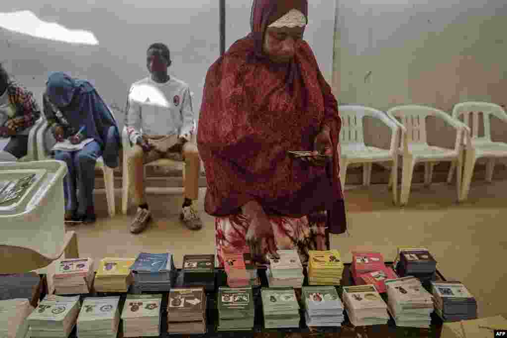 A woman picks up a ballot while voting at a polling station in Dakar, March 24, 2024 during the Senegalese presidential elections. 