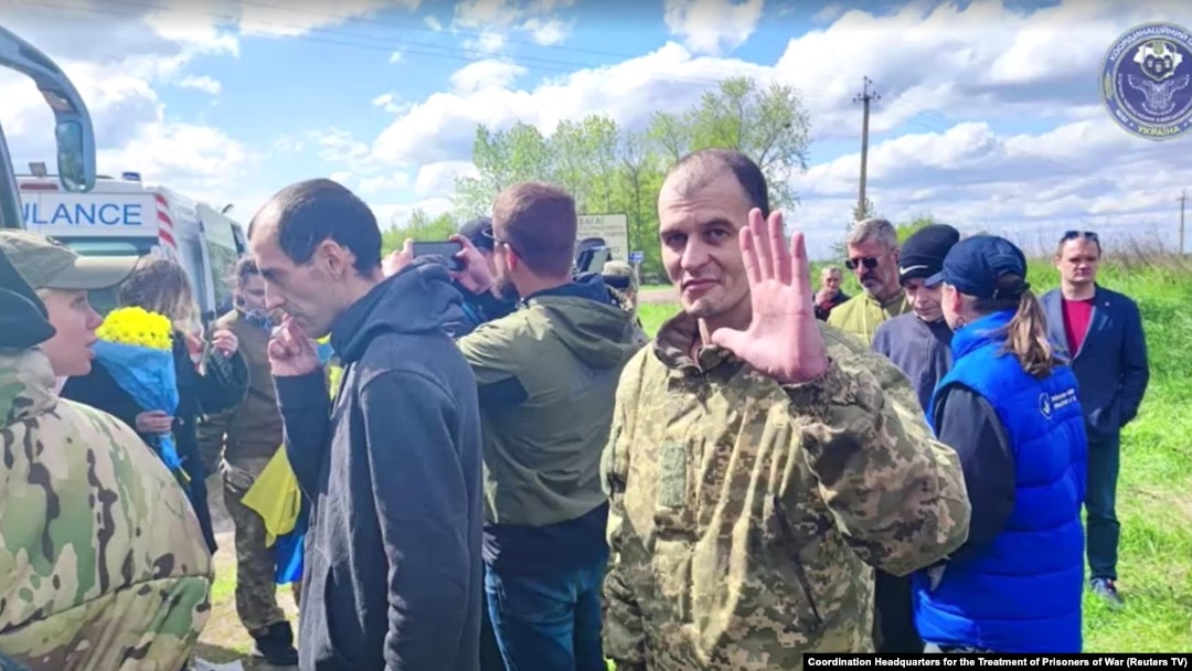 Ukrainian soldier waves at camera at an undisclosed location after being released from Russia, May 6, 2023.