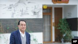 FILE - Virologist Zhang Yongzhen, the first scientist to publish a sequence of the COVID-19 virus, walks down a street in Shanghai, Dec. 13, 2020. Zhang was staging a sit-in protest after authorities locked him out of his lab. 