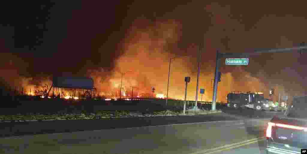 This photo provided by County of Maui shows fire and smoke filling the sky from wildfires on the intersection at Hokiokio Place and Lahaina Bypass in Maui, Hawaii, Aug. 8, 2023. (Zeke Kalua/County of Maui via AP)