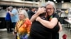 Angie Cox, à esquerda, e Joelle Henneman se abraçam após uma votação de aprovação para revogar a proibição do clero LGBTQ, na Conferência Geral da Igreja Metodista Unida, 1 de maio de 2024, em Charlotte, N.C.