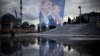 Pedestrians walk past a giant banner of Turkish President and People's Alliance's presidential candidate Recep Tayyip Erdogan, left, at Taksim Square in Istanbul, Turkey, May 10, 2023.