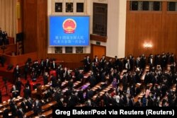 Para delegasi beristirahat selama sesi pleno keempat Kongres Rakyat Nasional (NPC) di Balai Besar Rakyat di Beijing pada 11 Maret 2023. (Foto: via Reuters)