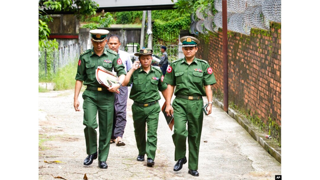 FILE - Myanmar military officers walk toward a township court during a trial of journalist Kyaw Min Swe, in Yangon, Myanmar, June 23, 2017.