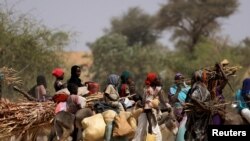 Sudanese refugees who fled the violence in Sudan's Darfur region and newly arrived ride their donkeys, near the border between Sudan and Chad in Goungour, Chad, May 8, 2023.