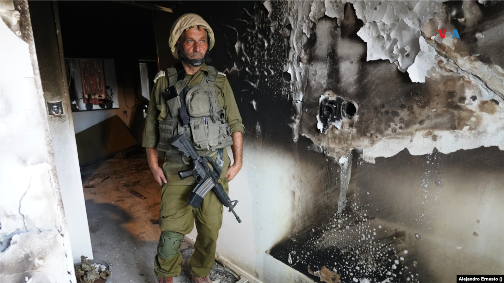 Un soldado de las Fuerzas de Defensa de Israel parado en una vivienda destruida durante el ataque de Hamás.