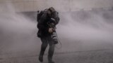 Getty Images photographer John Moore gets hit by a water cannon during clashes with riot police at a rally-march ahead of the 50th anniversary of the 1973 Chilean military coup, in Santiago, Chile, Sept. 10, 2023.