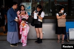Rickshaw puller Akina Suzuki organizes a guided tour for a family of customers from Taiwan around the Asakusa district, Tokyo, June 18, 2023.