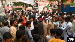 Tehreek-e-Insaf (PTI) party activists and supporters gather outside Pakistan's former Prime Minister Imran Khan's residence to listen his speech, in Zaman Park in Lahore on May 13, 2023. 