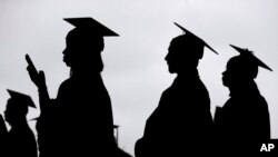 FILE - New graduates line up before the start of a college commencement in East Rutherford, NJ, May 17, 2018. 