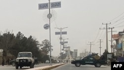 Personel keamanan Taliban (kanan) memblokir jalan di Mazar-i-Sharif , menyusul ledakan di kantor gubernur Taliban Mohammad Dawood Muzammil, di provinsi Balkh Afghanistan, 9 Maret 2023. (Atif ARYAN/AFP)