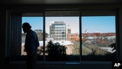 With a view of Portland, Ore., in the background, Cheyenne Welbourne walks in the common room at The Starlight affordable housing building on March 15, 2024.