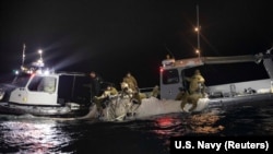 资料照片：美国海军提供的照片显示美军潜水员在南卡罗莱纳州海岸外打捞被击落的中国间谍气球碎片。（2023年2月7日）