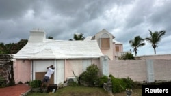 A man boards up a house to protect it from the approaching Hurricane Ernesto in Warwick, Bermuda, Aug. 16, 2024. 