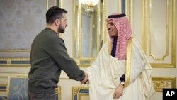 In this photo made available by the Ukrainian Presidential Press Office, Ukrainian President Volodymyr Zelenskyy, left, and Saudi Foreign Minister Prince Faisal bin Farhan al-Saud shake hands during their meeting in Kyiv, Ukraine, Feb. 26, 2023.