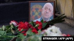 Um retrato de Yevgeny Prigozhin é visto no memorial improvisado em frente ao edifício do circo em Rostov-on-Don, a 24 de agosto de 2023.