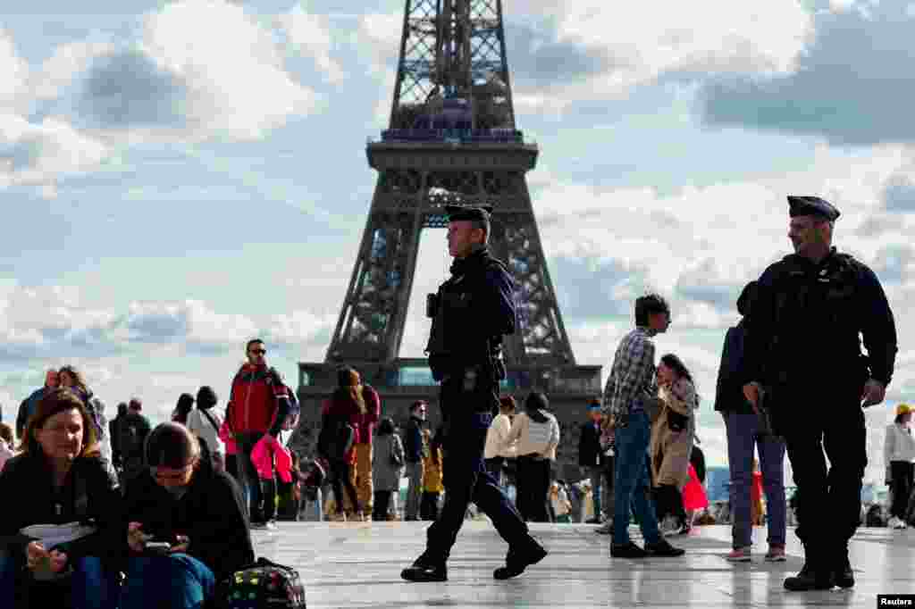 French police patrol at the Trocadero Square near the Eiffel Tower in Paris as the government puts nation on its highest state of alert after a deadly knife attack in northern France.