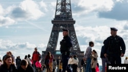 FILE - French police patrol at the Trocadero Square near the Eiffel Tower in Paris, Oct. 15, 2023. 