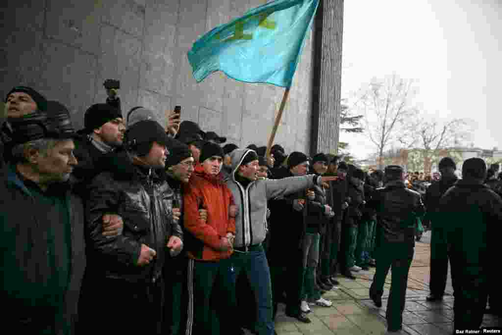 Los tártaros de Crimea sostienen la bandera de su pueblo durante una manifestación en el parlamento de Crimea en Simferopol el 26 de febrero de 2014. Una semana antes, un político de Crimea planteó la posibilidad de una &ldquo;secesión&rdquo; de la península de Ucrania. Los manifestantes callejeros de Kiev en ese momento estaban en el proceso de derrocar del poder al presidente prorruso Victor Yanukovich, lo que denominaron &ldquo;revolución de la dignidad&rdquo;.