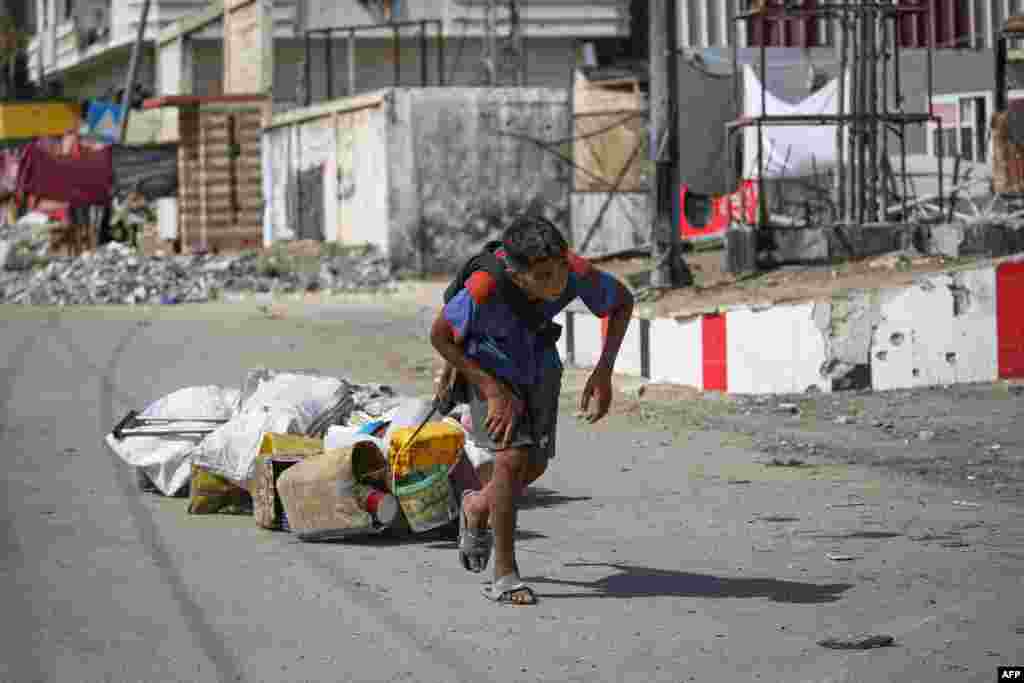 A Palestinian youth pulls salvaged items in Deir al-Balah in the central Gaza Strip amid the ongoing conflict between Israel and Hamas.