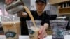 Seorang karyawan Ten Ren Tea di Flushing, Queens di New York, menuangkan seporsi bubble tea populer yang dilengkapi dengan mutiara tapioka beraroma lezat di bagian bawah setiap porsi, 29 Desember 2009. (AP/Kathy Willens)