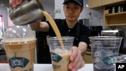 Seorang karyawan Ten Ren Tea di Flushing, Queens di New York, menuangkan seporsi bubble tea populer yang dilengkapi dengan mutiara tapioka beraroma lezat di bagian bawah setiap porsi, 29 Desember 2009. (AP/Kathy Willens)