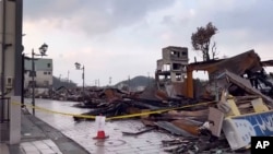 In this image from video provided by Yoshie Minamidani, a yellow tape blocks a street after a powerful earthquake in Wajima, Ishikawa prefecture, Japan, Jan. 2024. (Yoshie Minamidani via AP)