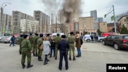 Ljudi se okupljaju na ulici, dok se dim diže u blizini zgrade koja pripada odeljenju granične patrole Federalne službe bezbednosti Rusije (FSB) u južnom gradu Rostovu na Donu, 16. mart 2023.