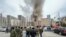 People gather in a street, as smoke rises near a building belonging to the border patrol section of Russia's FSB federal security service in the southern city of Rostov-on-Don, Russia, March 16, 2023. 