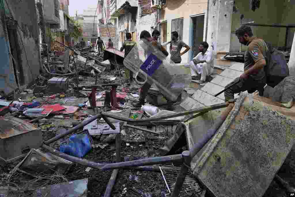 Police officers walk through the rubble of homes vandalized by an angry Muslim mob, Aug. 17, 2023. 